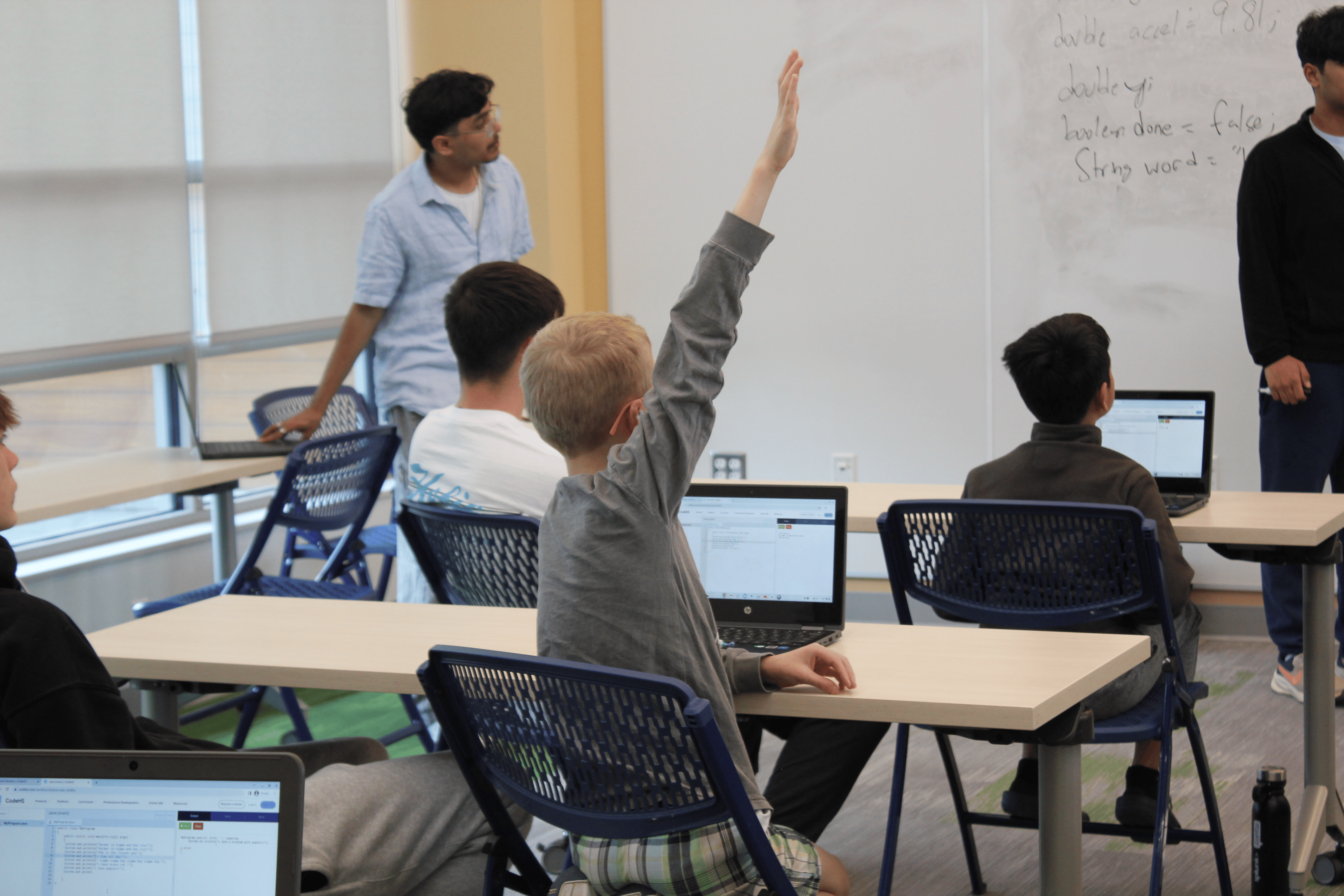 Students building a hands-on project together at a workshop table.