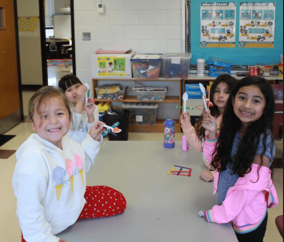 Students smiling during an indoor classroom activity.